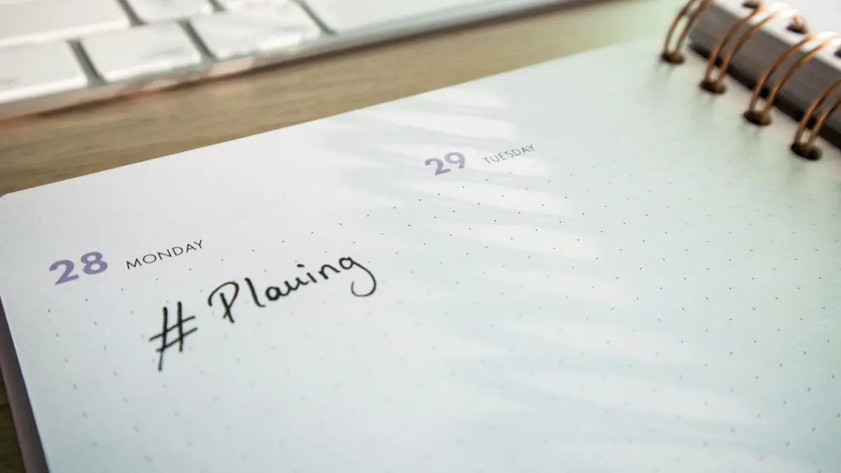 Agenda de papel aberta ao lado do teclado, para marcar visitas a imóveis