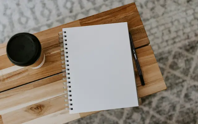 Folha em branco sobre mesa de madeira, pronta para escrever o anúncio do imóvel