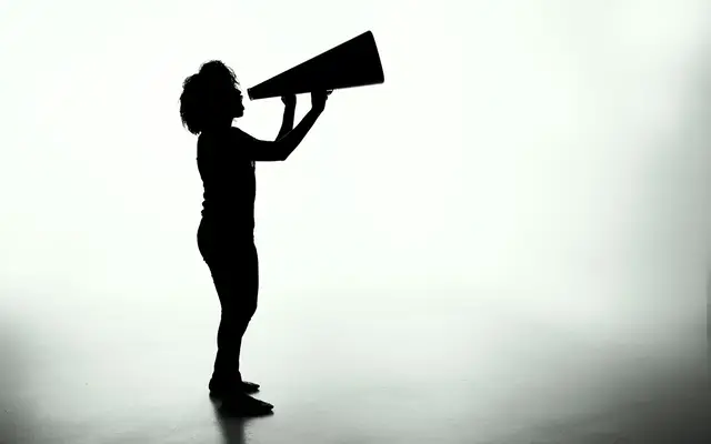 Silhueta de mulher segurando uma placa, como a mensagem enviada em massa pelo WhatsApp
