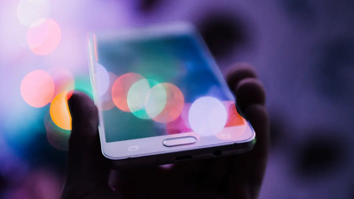 Pessoa segurando o celular, recebendo atendimento por inteligência artificial
